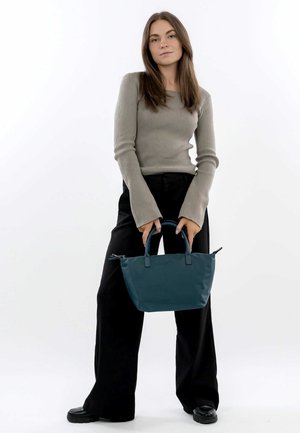 Borsa a mano color turchese realizzata in materiale liscio, con due manici corti e chiusura con zip, caratterizzata da una forma strutturata e design minimalista.