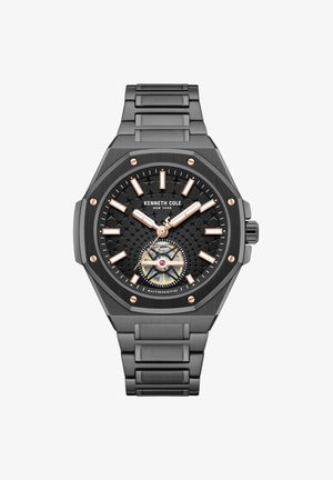 Kenneth Cole sort metalur med tekstureret urskive, roseguld timeindeks og visere, synlig automatisk værk og ledet armbåndsrem.