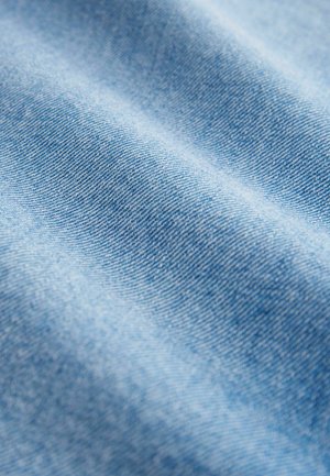 Lichtblau denim stof met een gladde textuur, met een fijne weving en subtiele variaties in tint, die de zachtheid en flexibiliteit benadrukken.