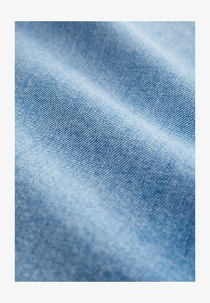 Lichtblau denim stof met een gladde textuur, met een fijne weving en subtiele variaties in tint, die de zachtheid en flexibiliteit benadrukken.