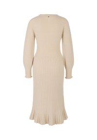 Beiges geripptes Strickkleid mit figurbetontem Oberteil, ausgestelltem Saum, langen Ärmeln und einer Knopfleiste am Hals. Strukturierte Verarbeitung insgesamt.