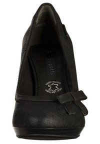 Chaussure à talon haut en cuir noir avec une finition texturée, un bout arrondi et un petit nœud décoratif sur le devant. Taille 37 visible à l'intérieur.