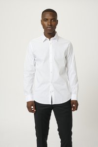 Cămașă albă cu mâneci lungi, guler și manșete cu nasturi, realizată dintr-un material neted, cu un croi clasic și un design minimalist.