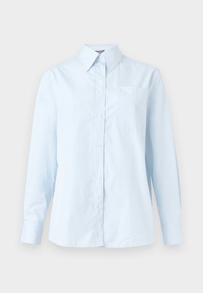 Ανοιχτό μπλε μακρυμάνικο πουκάμισο με κουμπιά, μυτερό γιακά και τσέπη στο στήθος, εμφανίζεται σε μονόχρωμο φόντο.