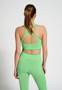 Grön aktivklädeset bestående av en sportbehå med racerback och utskärning samt matchande högmidjade leggings, båda i ett texturerat material.