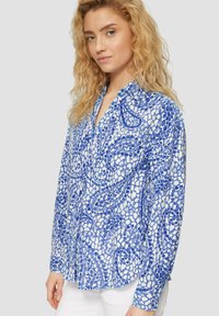 Blauw gestreept shirt met een mix van donkere en lichte blauwe vlekken, lange mouwen en een knoopsluiting kraag. Lichte stof met een ontspannen pasvorm.