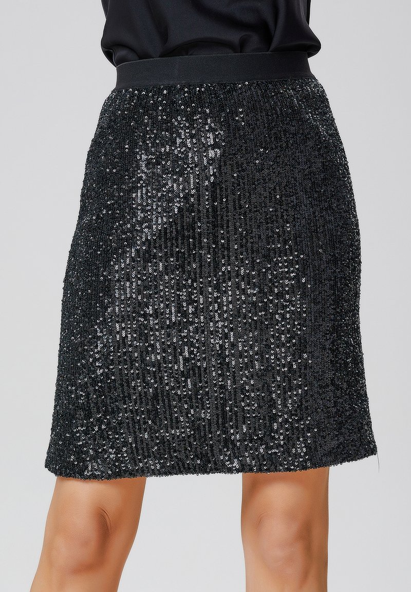 Jupe mini en sequins noirs avec une taille ajustée, présentant un motif vertical, une texture réfléchissante et une finition en tissu lisse.