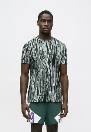 T-shirt met korte mouwen in zwart, grijs en wit met een abstract golvend patroon. Voorzien van een ronde halslijn en een comfortabele, losse pasvorm.