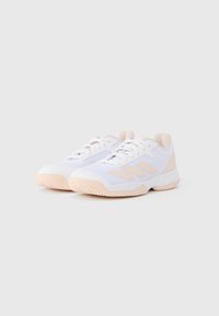 Zapatillas deportivas blancas con parte superior de malla transpirable, con detalles en rosa claro, suela de goma texturizada y diseño tradicional con cordones.