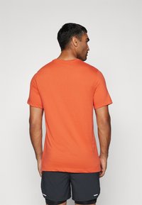 Nike Performance M NK DF TEE TRAIL LOGO - Športne majice - vintage coral/black