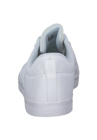 White sneaker with a smooth synthetic upper, padded collar, flat white sole, and a fabric heel tab for ease of wear. No visible patterns.
