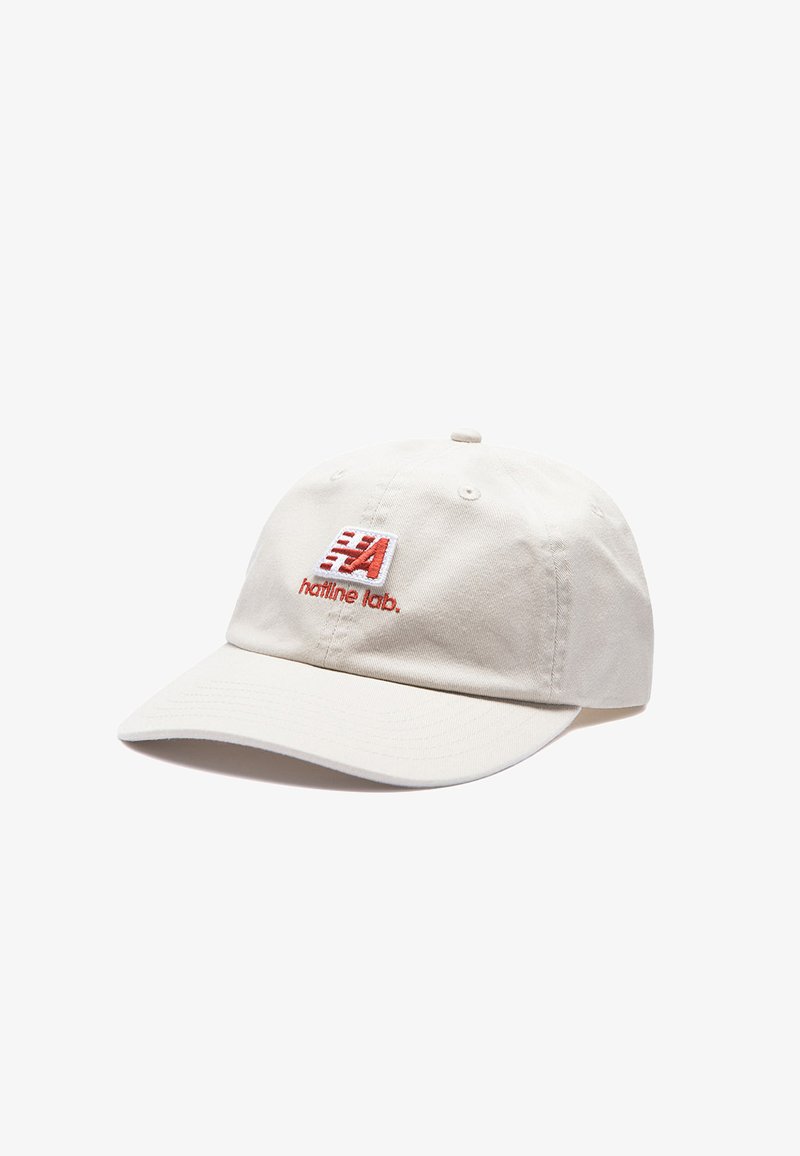 Casquette de baseball écrue à visière courbée avec un patch logo rouge et blanc et le texte "hatline lab." au centre avant.
