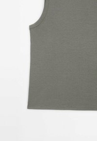 Débardeur côtelé sans manches de couleur vert olive, montrant la section supérieure du torse avec un col rond et un ourlet cousu.