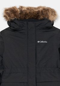Giacca invernale nera Columbia con cappuccio foderato in pelliccia sintetica e logo del marchio visibile sul petto.