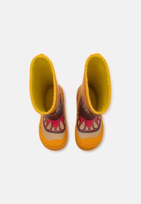 Bottes en caoutchouc jaunes vives avec un design de monstre comprenant une large bouche dentée et des couleurs vives, des semelles texturées et des intérieurs doux et rembourrés.