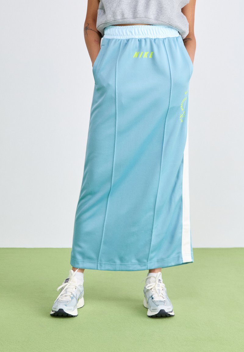 Gonna atletica lunga di colore blu chiaro con cintura elastica e dettagli del logo. Presenta strisce laterali bianche e una texture liscia e sintetica.