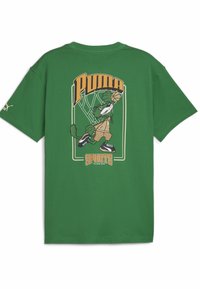 Camiseta de algodón verde con un gráfico de un personaje de dibujos animados jugando al baloncesto, con el texto "PUMA" y "DEPORTES" en colores contrastantes.
