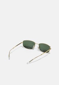 Lunettes de soleil en métal doré avec des verres rectangulaires verts, des branches fines et des embouts en acétate transparent ; comporte de petits accents décoratifs sur la monture.