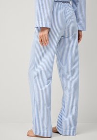 Blauw-witte gestreepte pyjamabroek van zachte stof, met een rechte snit, elastische tailleband en stiksel-details op de benen.