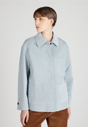 Helle blaue Kordjacke mit einem Umlegekragen, vorderer Knopfverschluss und zwei Fronttaschen. Weiche Textur mit vertikalem Rippmuster.