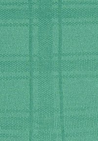 Textiel met een gestructureerde weving in een effen turquoise kleur, met een subtiel ruitpatroon. De stof lijkt zacht en duurzaam.