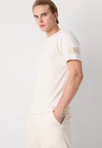 Calvin Klein Jeans BADGE REGULAR TEE - Pamata T-krekls - ivory