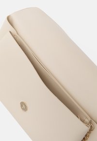 Beige strukturovaná kabelka na dokumenty s texturovaným povrchem, se zlatým patentním zapínáním a vnitřní kapsou na zip.