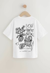 Biała bawełniana koszulka z czarnym rysunkiem wazonu z kwiatami, koszykiem chleba i napisem "BON APPÉTIT AMOUR".