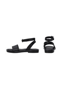 Zwarte leren sandalen met een platte zool, brede voorband en verstelbare enkelband. Minimalistisch ontwerp met een soepele textuur.