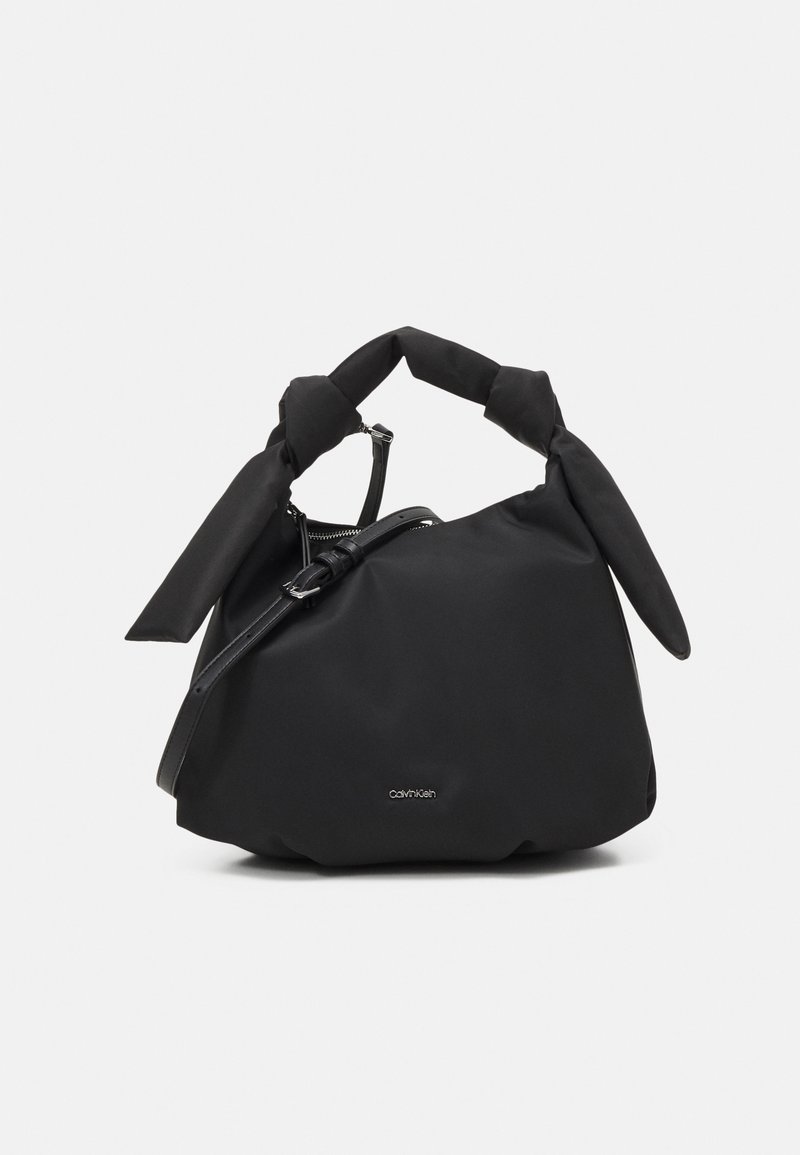 Borsa in tessuto nero con manici annodati, texture liscia e dettagli in metallo color argento. Dotata di chiusura con zip e piccolo logo.