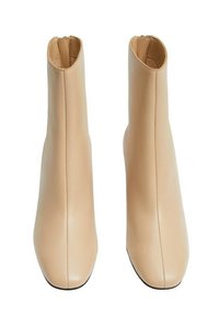 Botines de piel beige con un diseño elegante, cierre de cremallera en la parte trasera y puntera redondeada. Textura suave con detalles de costura mínimos.