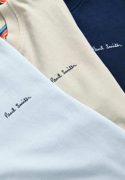 Drei T-Shirts von Paul Smith in Blau, Beige und Marine. Weicher Baumwollstoff mit einer glatten Textur und gesticktem Logo auf jedem Shirt.