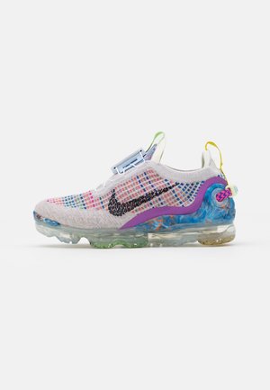Kolorowy sneaker Nike z wielobarwną dzianinową cholewką, czarnym logo, niebieskimi i żółtymi pętlami na pięcie oraz przezroczystą podeszwą z zielonymi i niebieskimi akcentami.