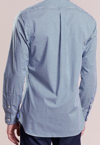 Ljusblå och marinblå rutigt skjorta, långa ärmar, knappmanschetter, detalj med veck på baksidan, mjukt bomullstyg, figursydd design.