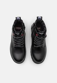 Black high-top boots with a smooth leather finish, gray patterned laces, and a logo tag at the heel. The outsole is sturdy and textured.