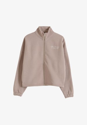 Beige Kapuzenpullover mit Reißverschluss, hohem Kragen, langen Ärmeln mit elastischen Bündchen und kleinem weißen Schriftzug auf der linken Brust.