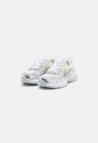 White and silver mesh running shoes with a padded collar, textured surface, laces, and a rubber sole featuring a reflective Swoosh logo.