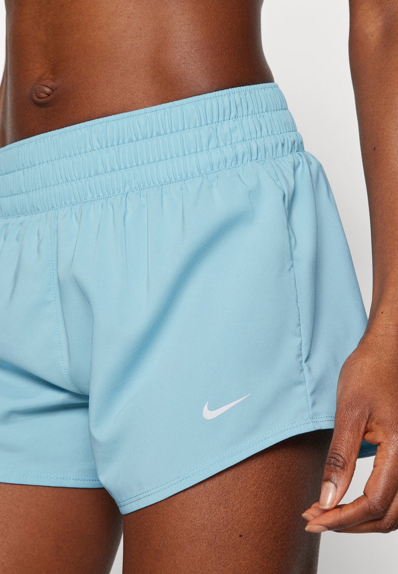 Hellblaue Sportshorts aus glattem Material mit einem elastischen Bund und einem weißen Nike-Logo auf der unteren linken Seite.