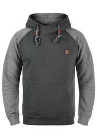 Sudadera con capucha en gris oscuro con mangas raglán gris claro. Cuenta con cordones, un bolsillo frontal y un pequeño parche con logo en el pecho.