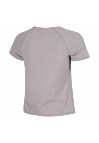 Camisa de manga corta de color lila claro con un sutil patrón abstracto, con costuras visibles a lo largo de las mangas raglán, mostrada desde la parte posterior sobre un fondo blanco.