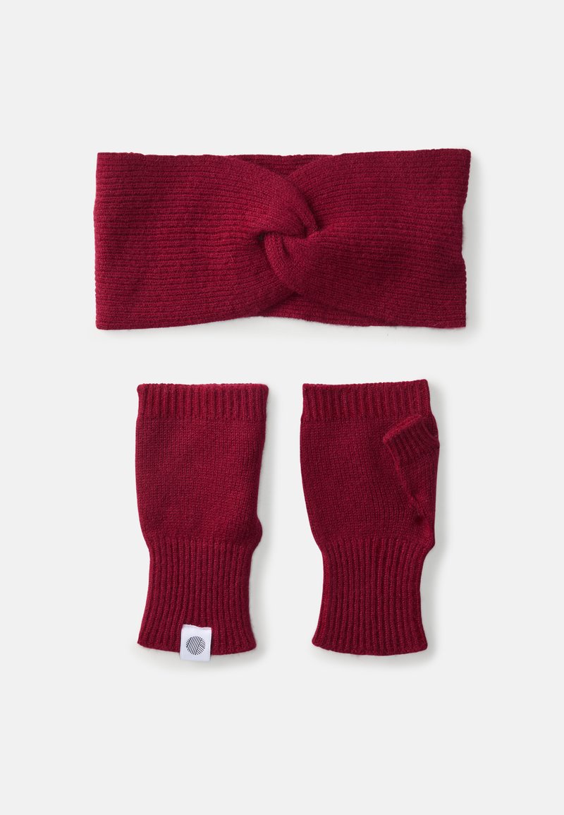Fascia in magenta lavorata a maglia con design a nodo attorcigliato, abbinata a guanti senza dita con polsini a coste e una piccola etichetta con logo.