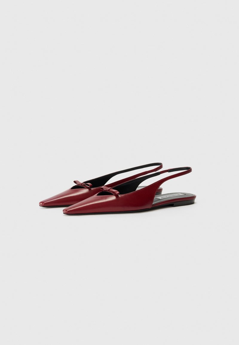 Røde læderslingback flade sko med spidse tåer, lille sløjfedetalje foran og en lav hæl. Glat tekstur, minimalistisk design.