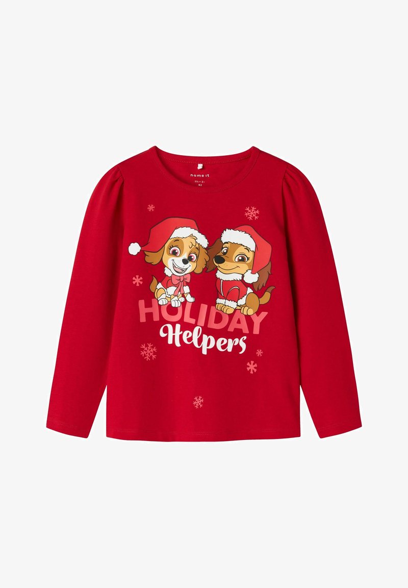 Pikkade varrukatega punane särk, millel on kaks koomiksikoera jõuluvana mütsides. Tekst ütleb "PUHKUSE AITAJAD" lumekristallide aktsentidega. Pehme puuvillane materjal.