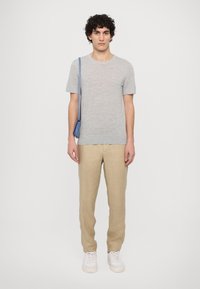 Gray short-sleeve t-shirt, beige linen pants, white sneakers. Blue shoulder bag, plain design, smooth texture, relaxed fit.