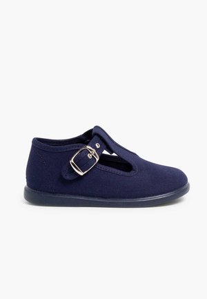 Chaussure en toile navy avec design en T, boucle argent ajustable et semelle en caoutchouc. Texture lisse et découpes latérales ouvertes pour une meilleure respirabilité.