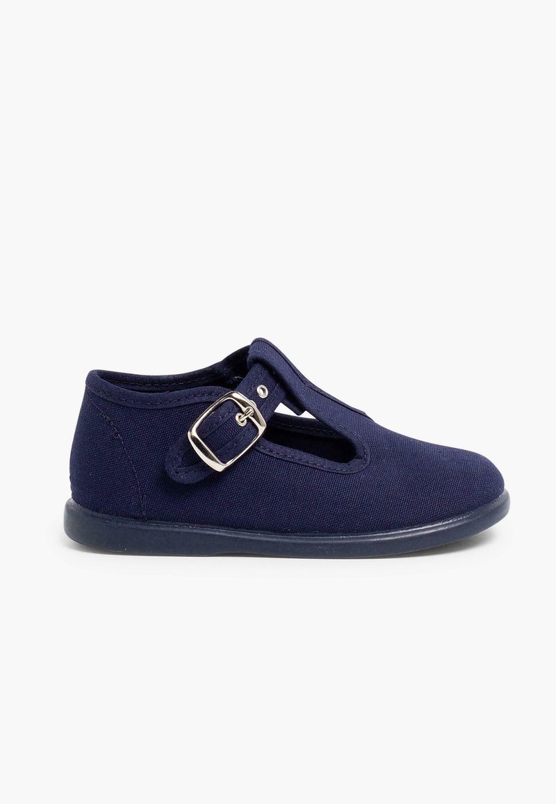 Zapato de lona azul marino con diseño de tira T, hebilla ajustable plateada y suela de goma. Textura suave y cortes laterales abiertos para transpirabilidad.