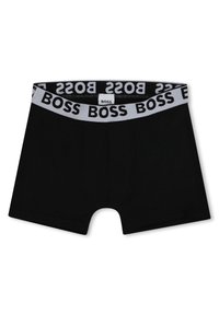 Boxer-briefs noirs avec une taille douce portant le mot "BOSS" en gros caractères noirs. Fabriqués en tissu lisse avec un design ajusté.