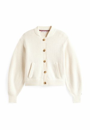 Cardigan lavorato a maglia color crema con scollo rotondo, cinque grandi bottoni, polsini a coste e due tasche frontali. Texture morbida, vestibilità cropped.