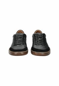 Chaussures en cuir noir et en daim avec une tige texturée, bout rond et lacets fins, dotées d'une semelle en caoutchouc et de détails perforés.