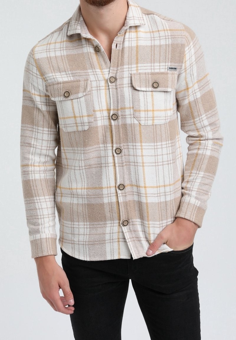 Camicia di flanella a quadri beige con accenti bianchi e gialli, maniche lunghe, apertura a bottoni, due tasche sul petto e una texture morbida.